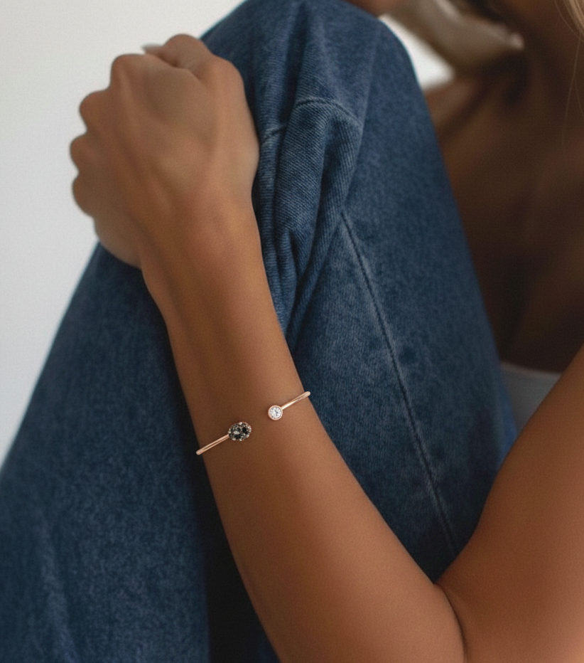 Person wearing a bracelet with a blue denim jacket on a neutral background