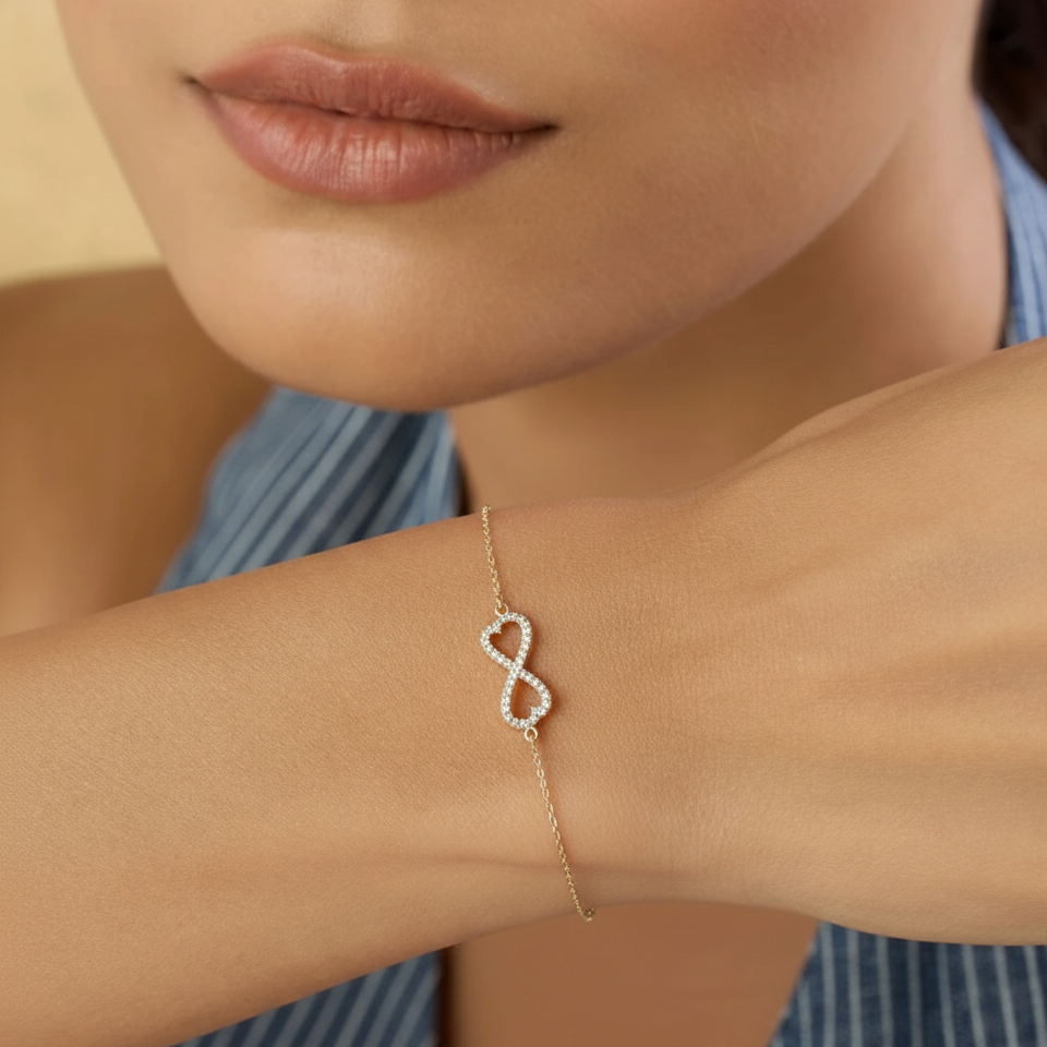 Close-up of a person wearing a delicate bracelet with a heart design on a blue striped shirt.