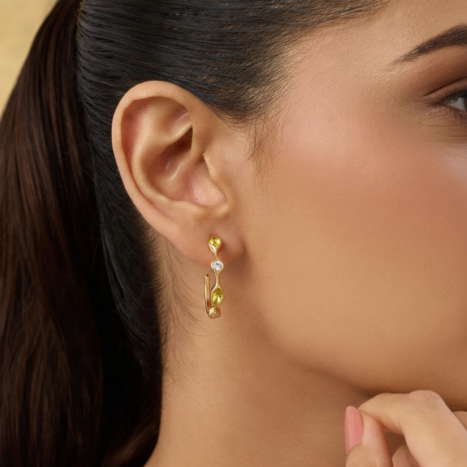 Close-up of a woman wearing gold earrings with a neutral background