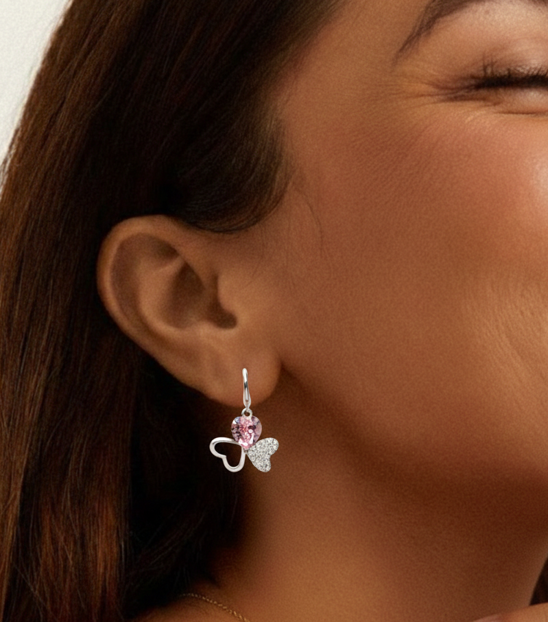 Close-up of a woman wearing a silver earring with a pink gemstone.