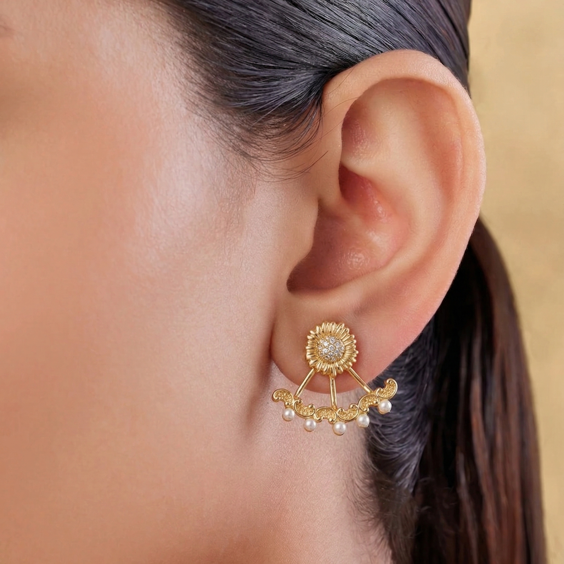 Gold earring with pearls worn by a person