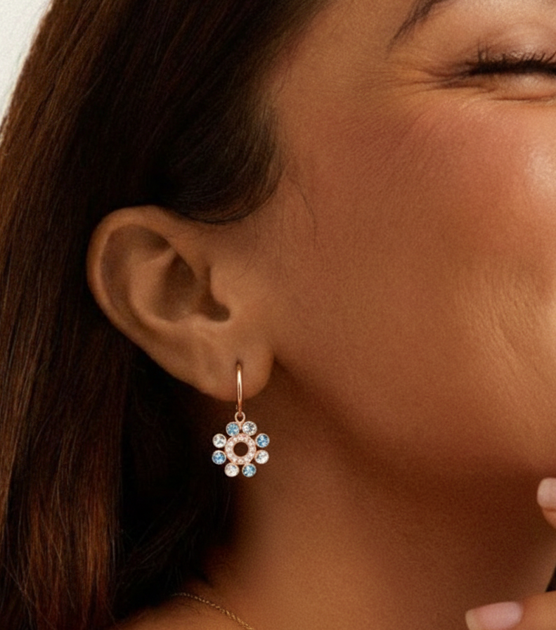 Close-up of a woman wearing a floral earring with a neutral background