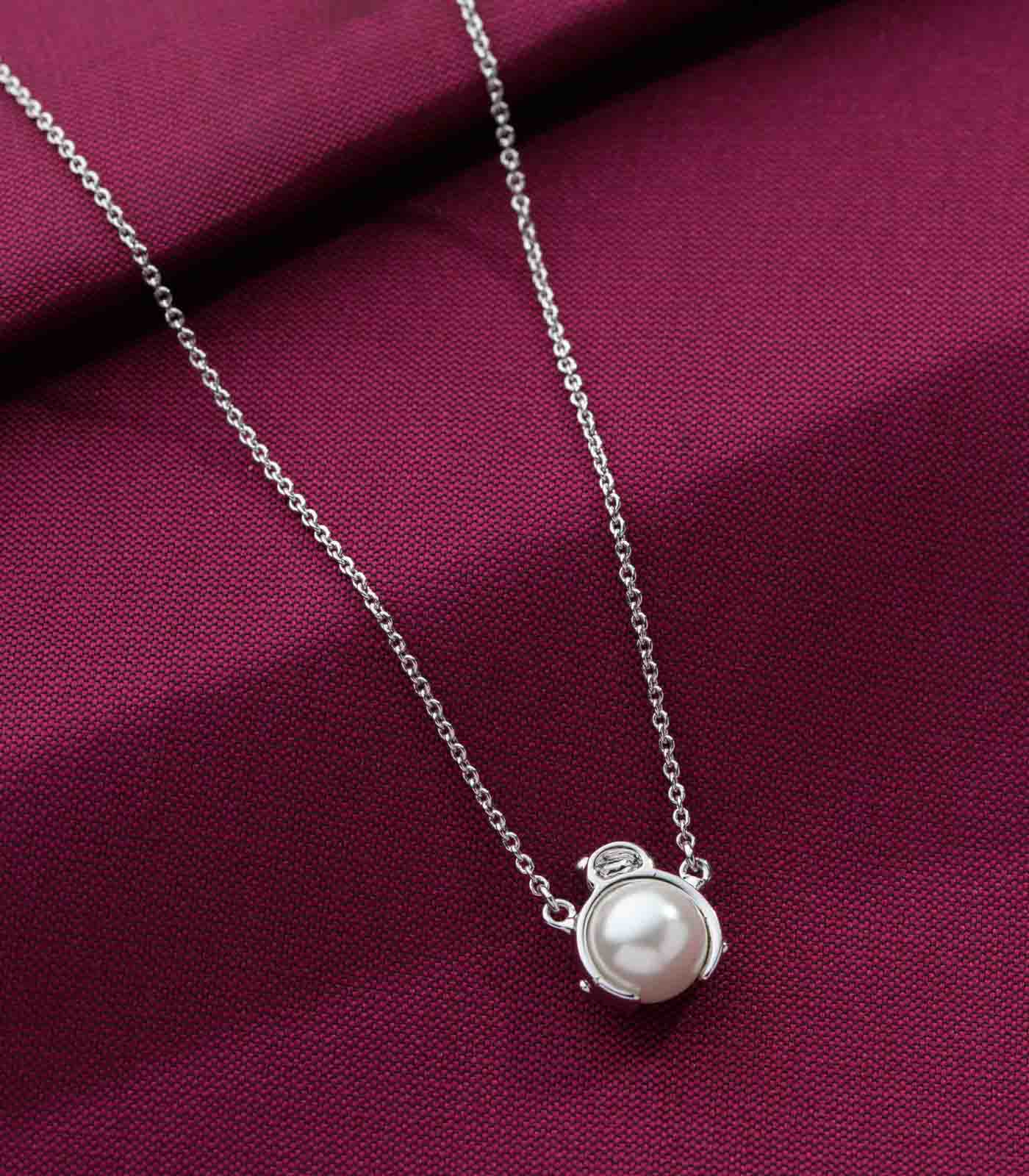 Pearl necklace on a purple fabric background