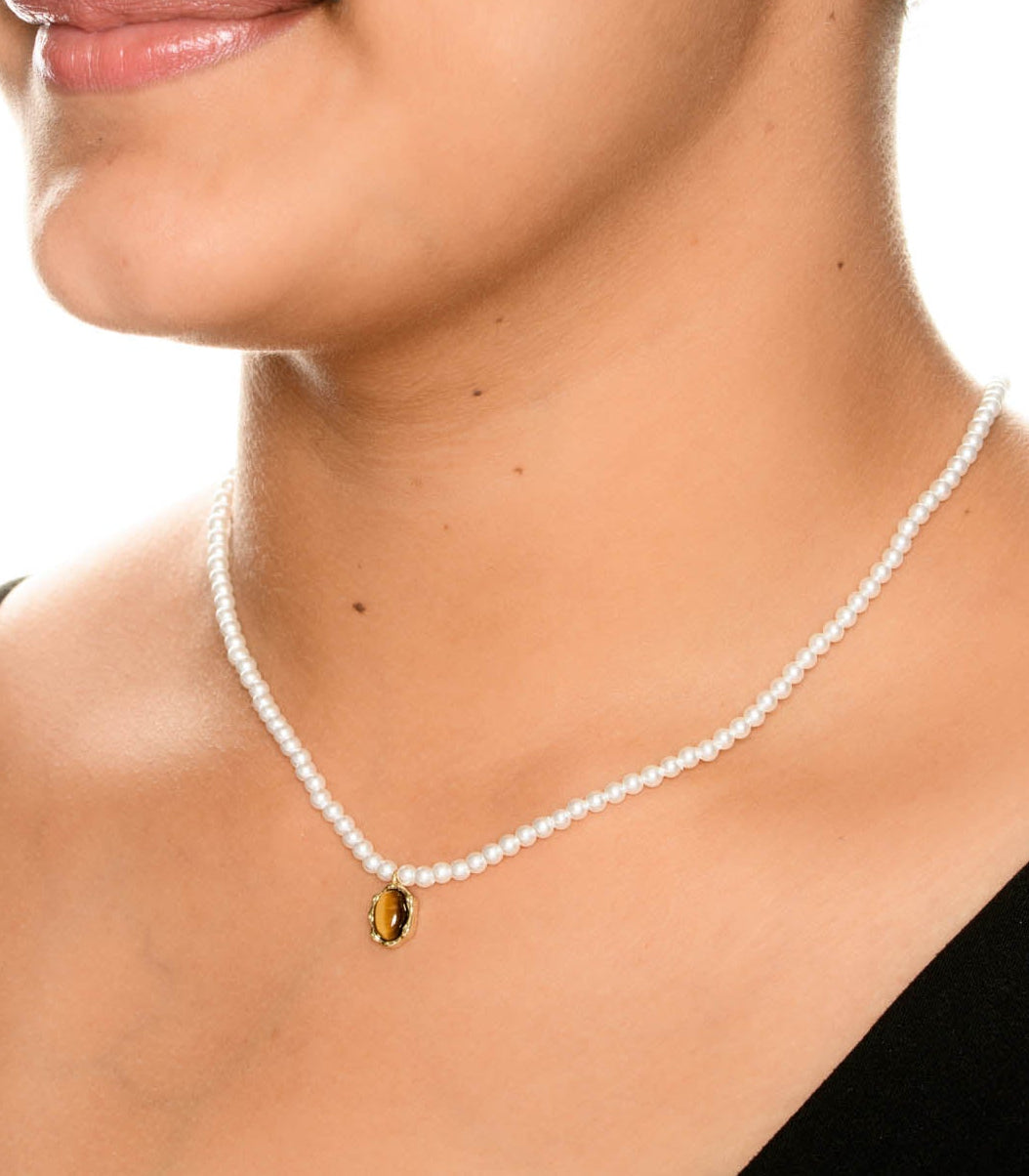 Pearl necklace with a pendant worn by a person on a white background