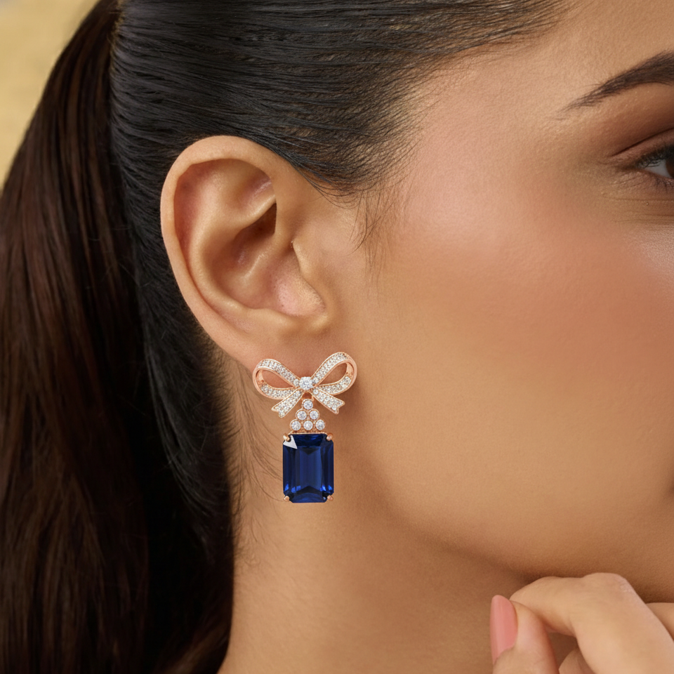 Close-up of a woman wearing a blue gemstone earring with a bow design.