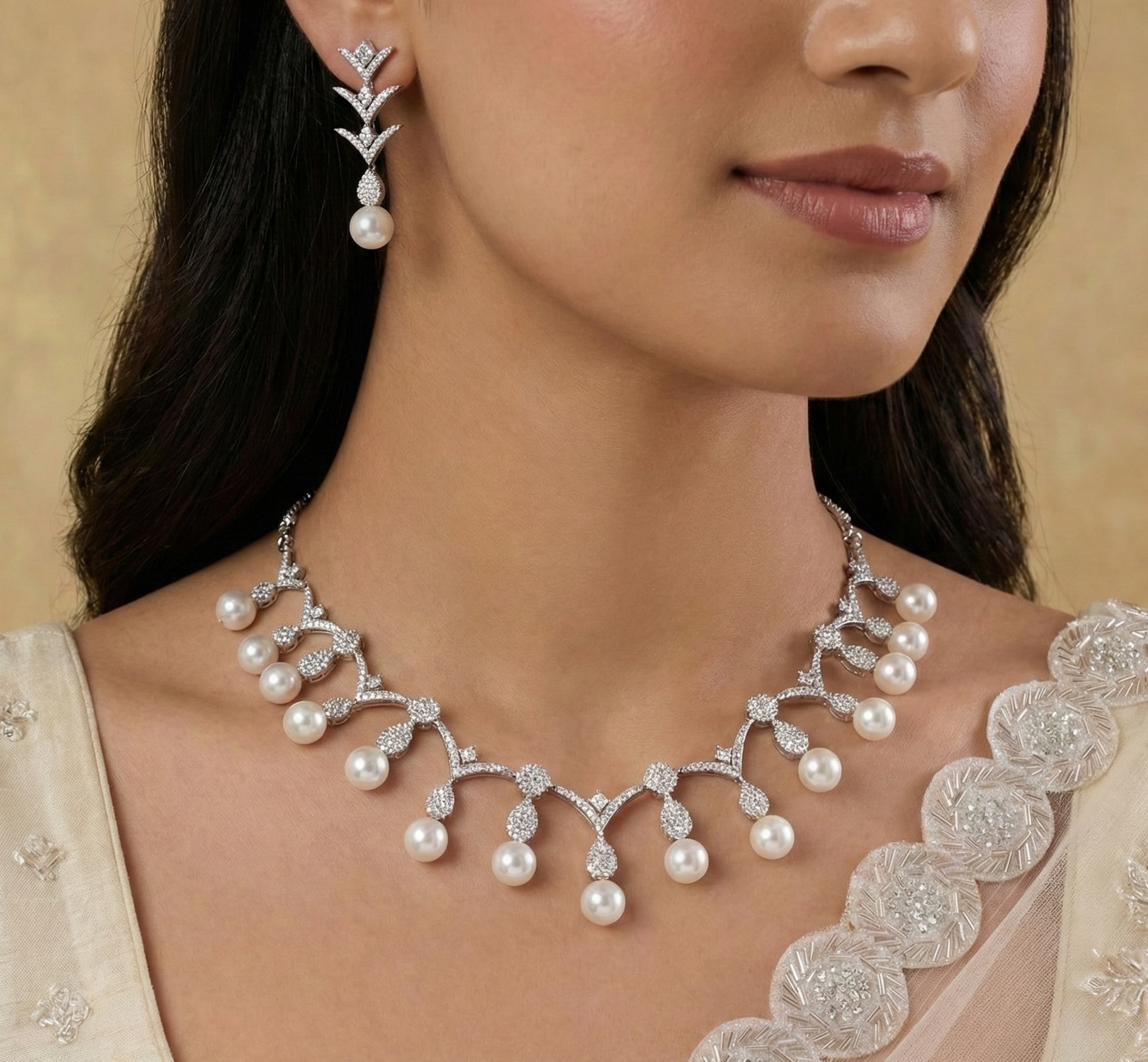 Woman wearing a pearl necklace and earrings with a beige background