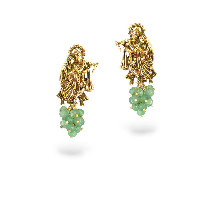 Gold earrings with green gemstones on a white background
