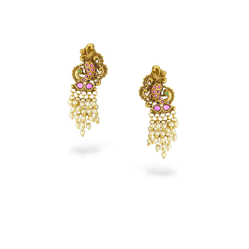 Gold earrings with pink gemstones on a white background