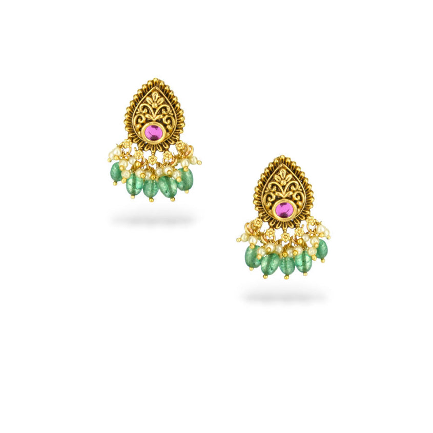 Gold earrings with green beads and pink stones on a white background