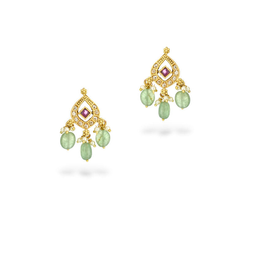 Gold earrings with green gemstones on a white background