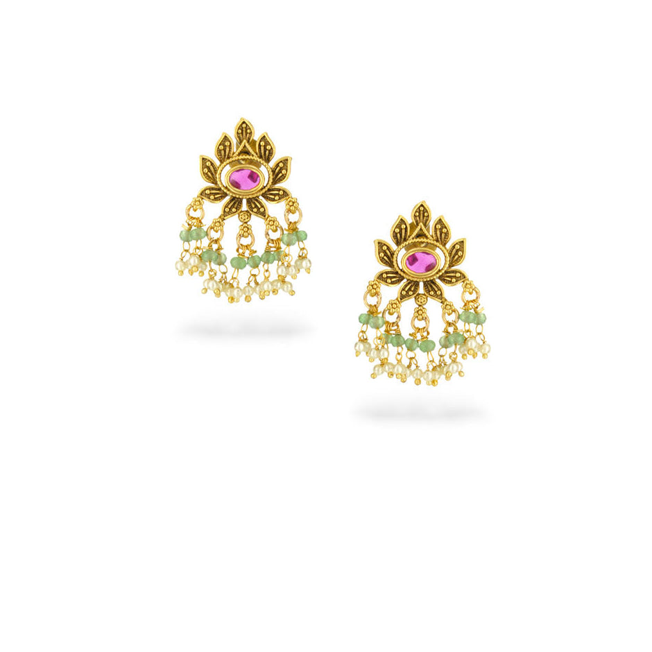 Gold earrings with pink and green stones on a white background