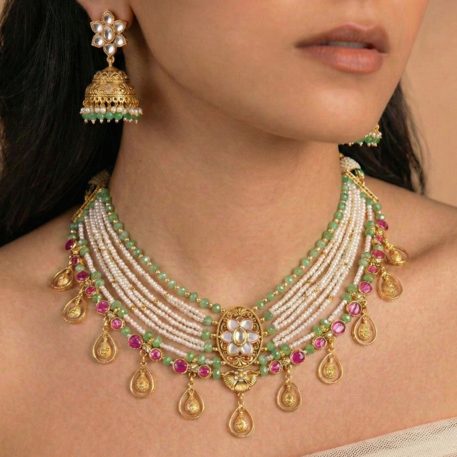 Delicate necklace with green and pink stones worn by a model